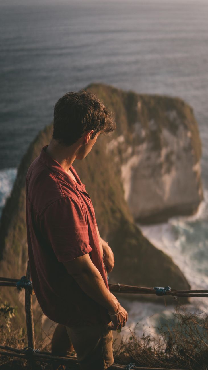 Editorial travel writer observing coastal sunset over cliffs